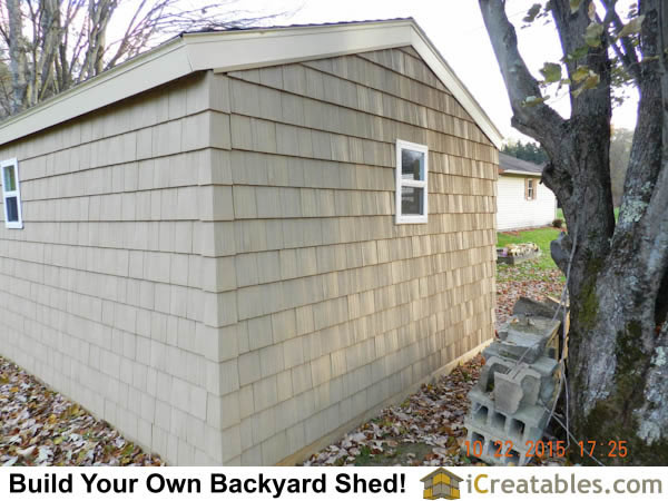Rear corner of shed showing close up of shed vinyl shake style siding installed on storage shed.