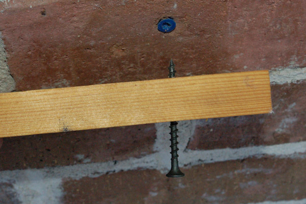 driving screw through wood into plastic concrete anchor