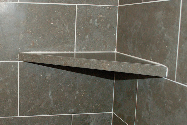 shower corner shelf on top of tile course